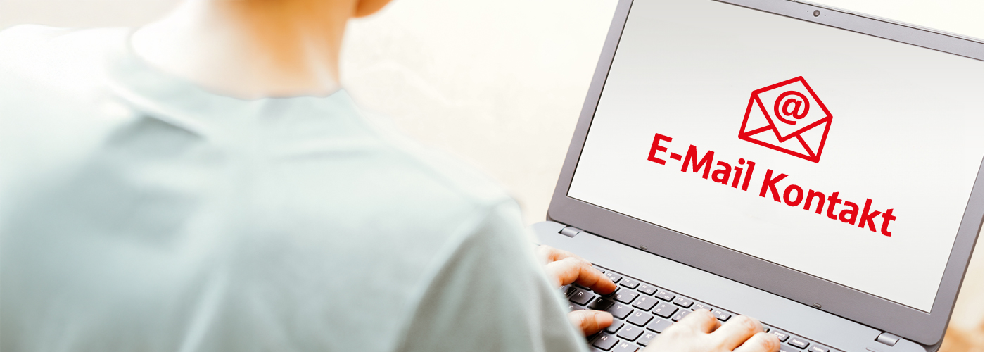 Eine Person sitzt mit dem Rücken zum Betrachter an einem Laptop. Auf dem Bildschirm ist ein E-Mail-Piktogramm in roter Farbe mit dem Text E-Mail Kontakt zu sehen.
