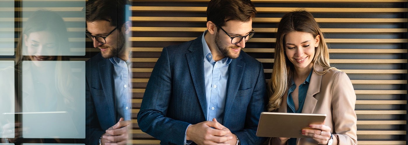 The picture shows a young woman and a young man in business attire.