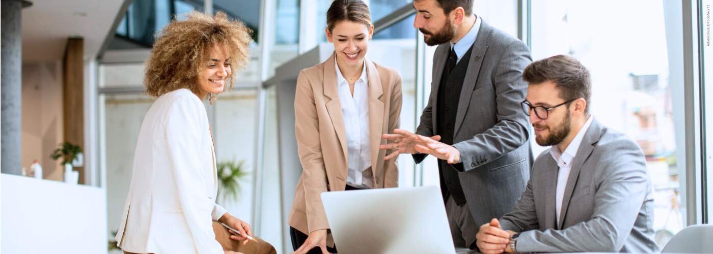 Eine vierköpfige Gruppe von Geschäftsleuten arbeitet im Büro zusammen.