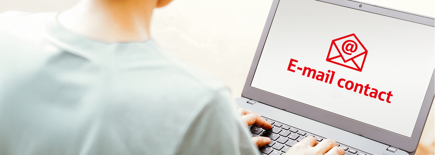 A person is sitting at a laptop with their back to the viewer. An email pictogram in red with the text Email contact can be seen on the screen.