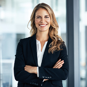 The picture shows a smiling woman with long blonde hair wearing a suit.