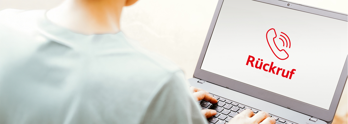 Eine Person sitzt mit dem Rücken zum Betrachter an einem Laptop. Auf dem Bildschirm ist ein Piktogramm in roter Farbe mit dem Text Rückruf zu sehen.